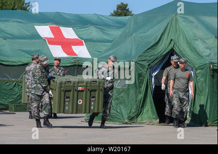 Feldkirchen, Germania. 04 Luglio, 2019. I soldati del popolo cinese della Esercito di Liberazione trasportare una scatola davanti ad un mobile della stazione di salvataggio. Medical soldati del popolo cinese della Esercito di Liberazione hanno avviato un esercizio con la Bundeswehr in Baviera. Fino al 17 luglio, lo scenario di una comune missione ONU saranno addestrati a Feldkirchen nella Bassa Baviera. Credito: Armin Weigel/dpa/Alamy Live News Foto Stock