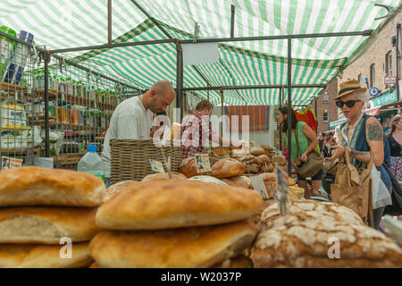 Londra Inghilterra - Luglio 13 2013; acquirenti e vedors nel panificio di stallo del mercato nella zona est di Londra mercato del weekend Foto Stock