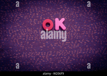 La parola OK con colorati blocchi lettera su tessuto Foto Stock