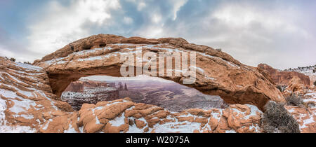 Visualizzazione classica del famoso Mesa Arch, simbolo del sud-ovest americano, illuminata a scenic golden. La luce del mattino al sorgere del sole su una bella giornata invernale in Foto Stock