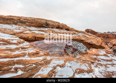 Visualizzazione classica del famoso Mesa Arch, simbolo del sud-ovest americano, illuminata a scenic golden. La luce del mattino al sorgere del sole su una bella giornata invernale in Foto Stock