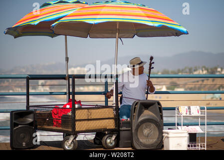 LA, Stati Uniti d'America - 30 OTTOBRE 2018: un suonatore ambulante suona uno strumento musicale sul molo di Santa Monica per i turisti in visita a Los Angeles, California. Foto Stock