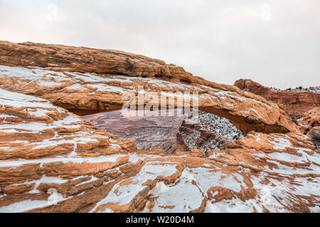 Visualizzazione classica del famoso Mesa Arch, simbolo del sud-ovest americano, illuminata a scenic golden. La luce del mattino al sorgere del sole su una bella giornata invernale in Foto Stock