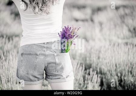 Bouquet di porpora viola Lavanda fiori nella tasca dei jeans. Foto in bianco e nero, luminoso bouquet. Spazio di copia Foto Stock