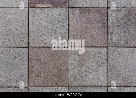 Close-up di un po' sporca e weathered square pietre per pavimentazione o blocchi esterni visto dal di sopra. Alta risoluzione full frame sfondo a trama. Foto Stock