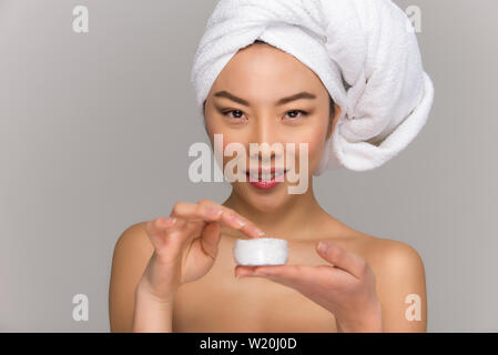 Bella donna asiatica bellezza ritratti. Ragazza cinese in piedi di fronte allo specchio e di prendersi cura del suo sguardo. studio di bellezza scatti Foto Stock