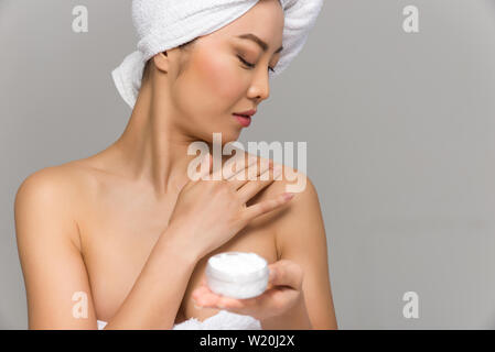 Bella donna asiatica bellezza ritratti. Ragazza cinese in piedi di fronte allo specchio e di prendersi cura del suo sguardo. studio di bellezza scatti Foto Stock