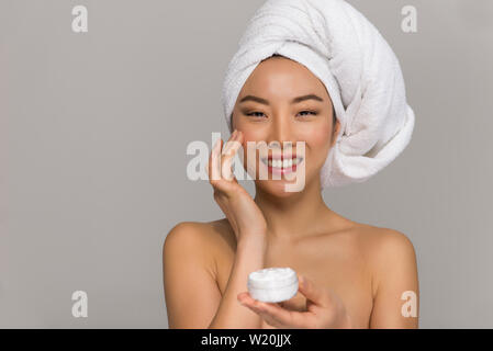 Bella donna asiatica bellezza ritratti. Ragazza cinese in piedi di fronte allo specchio e di prendersi cura del suo sguardo. studio di bellezza scatti Foto Stock