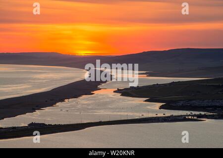 Portland, Dorset, Regno Unito. 4 luglio 2019. Regno Unito Meteo. Uno spettacolare tramonto oltre la flotta laguna e Chesil Beach sul Dorset Jurassic Coast visto dall'isola di Portland. Credito Foto: Graham Hunt/Alamy Live News Foto Stock