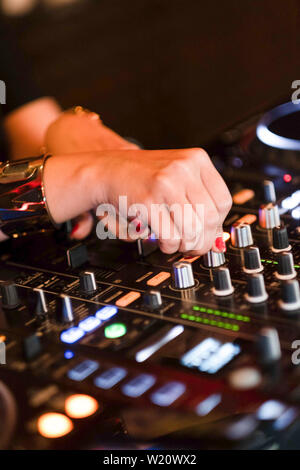 Dettaglio della donna dj miscelazione le mani sulla console. Close-up di musica di apparecchiature di miscelazione. Foto Stock