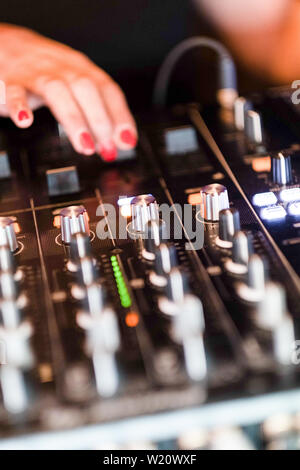 Dettaglio della donna dj miscelazione le mani sulla console. Close-up di musica di apparecchiature di miscelazione. Foto Stock