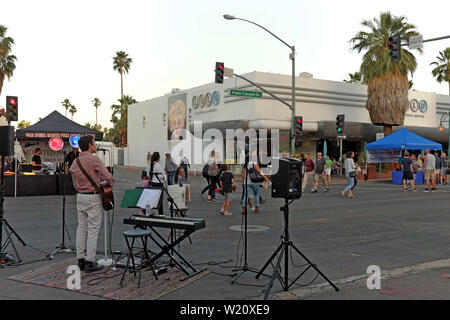 La gente apprezza il Villagefest nel centro di Palm Springs, California. La fiera di strada del giovedì sera propone arte, artigianato, cibo e intrattenimento. Foto Stock