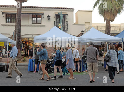 La gente apprezza il Villagefest nel centro di Palm Springs, California. La fiera di strada del giovedì sera propone arte, artigianato, cibo e intrattenimento. Foto Stock