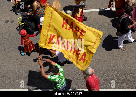 Hare Krishna bandiera portato in un mese di marzo durante il 2019 St Kilda festival celebrazioni, ripresa dall'alto a Melbourne, Australia. Foto Stock