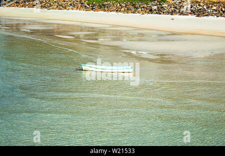 Imbarcazioni in vetroresina parcheggiato sulla spiaggia e spazzatura sulle rocce a Koh Phangan, Surat Thani in Tailandia. Foto Stock