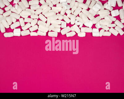 Schiuma bianca materiale di riempimento per riempire i pacchi durante il trasporto su un sfondo rosa, spazio di copia Foto Stock
