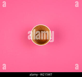 Vuoto Utilizzato carta rossa tazza da caffè sotto sorge su sfondo rosa, vista dall'alto Foto Stock