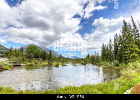 Poliziotto's Creek Boardwalk è un panoramico sentiero escursionistico nella città di Canmore, Alberta, che segue un fiume con le Montagne Rocciose Canadesi in background Foto Stock