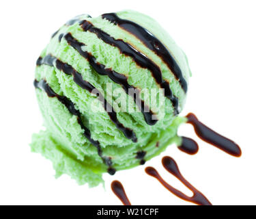 Un cucchiaio di menta gelato condito con salsa di cioccolato isolato su sfondo bianco Foto Stock