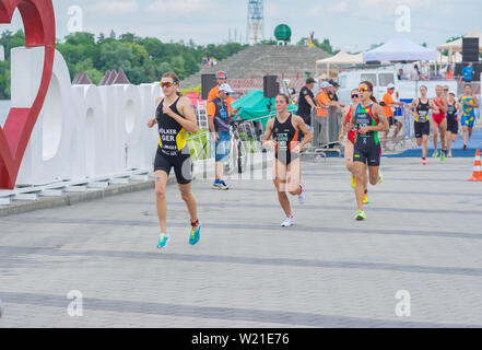 DNIPRO, Ucraina - Giugno 08, 2019: gruppo di atlete in esecuzione su un terrapieno di città nel corso del '2019 Dnipro ETU Triathlon sprint di Coppa Europea" Foto Stock