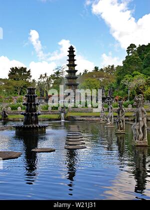 Tirta Gangga acqua Palace è un labirinto di piscine e fontane e circondati da un lussureggiante giardino e di sculture in pietra e statue. Si trova a Karangasem, Bali. Foto Stock