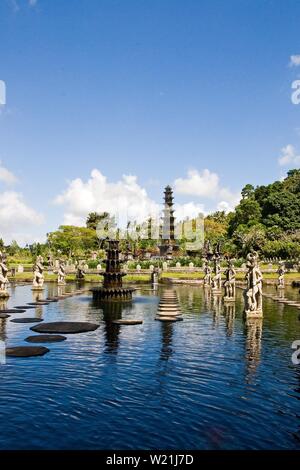 Tirta Gangga acqua Palace è un labirinto di piscine e fontane e circondati da un lussureggiante giardino e di sculture in pietra e statue. Si trova a Karangasem, Bali. Foto Stock