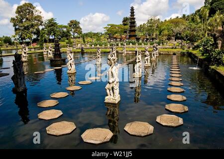 Tirta Gangga acqua Palace è un labirinto di piscine e fontane e circondati da un lussureggiante giardino e di sculture in pietra e statue. Si trova a Karangasem, Bali. Foto Stock