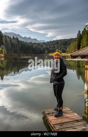 Giovani femmine escursionista in piedi su un ponte pedonale a Grubsee, vicino Krun, Karwendel, Alta Baviera, Baviera, Germania Foto Stock