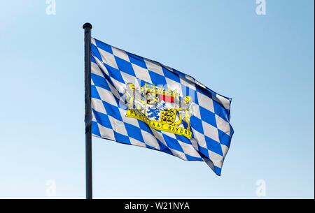 Un blu-bandiera bianca con lo stemma dello Stato libero di Baviera soffia il vento in Markt della Svevia, Baviera, Germania Foto Stock