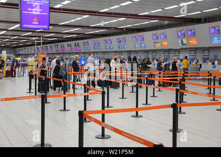 L'aeroporto London Luton, Regno Unito, check-in sala. I passeggeri Easyjet coda per il check-in per i voli. Luton di check-in hall ha 62 scrivanie in una singola linea. Foto Stock