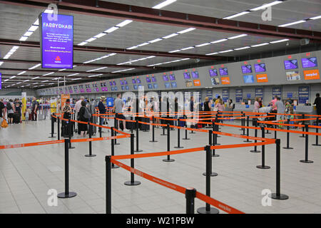 L'aeroporto London Luton, Regno Unito, check-in sala. I passeggeri Easyjet coda per il check-in per i voli. Luton di check-in hall ha 62 scrivanie in una singola linea. Foto Stock