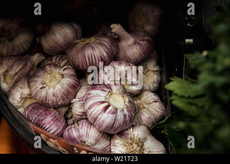 Una inquadratura ravvicinata di un abbondanza di aglio fresco lampadine su display a un mercato in stallo. Foto Stock