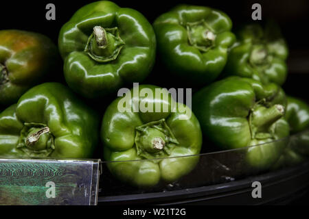 Una inquadratura ravvicinata di un abbondanza di prodotti freschi peperoni verdi sul display a un mercato in stallo. Foto Stock