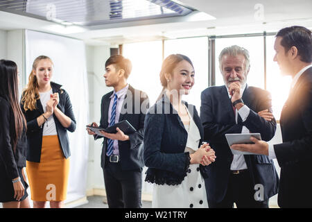 Un gruppo di uomini di affari che incontro di discussione il concetto di lavoro nella sala riunioni Foto Stock