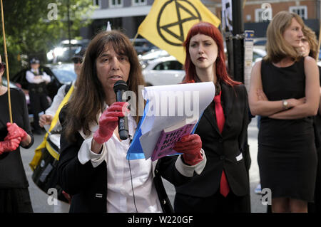 London, Greater London, Regno Unito. 2 Luglio, 2019. Attivista ambientale parla mentre si tiene un microfono durante una manifestazione di protesta a Londra.la ribellione di estinzione gli ambientalisti hanno marciato in un corteo silenzioso denominate " XR Carmen la processione di carbonio'' attraverso il centro di Londra per visitare 5 diversi uffici di petrolio società tra cui ENI, CPCN, SAUDI ARAMCO, Repsol, BP. Hanno fermato presso la sede centrale di olio per dichiarare un 'crime scene'' e consegnare una lettera e copie della XR handbook. Attivista ambientale richiesta da società petrolifere per smettere di esplorare di più combustibili fossili. (Credito mi Foto Stock