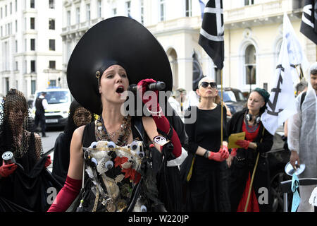 London, Greater London, Regno Unito. 2 Luglio, 2019. Attivista ambientale parla mentre si tiene un microfono al di fuori sede Repsol durante una manifestazione di protesta a Londra.la ribellione di estinzione gli ambientalisti hanno marciato in un corteo silenzioso denominate " XR Carmen la processione di carbonio'' attraverso il centro di Londra per visitare 5 diversi uffici di petrolio società tra cui ENI, CPCN, SAUDI ARAMCO, Repsol, BP. Hanno fermato presso la sede centrale di olio per dichiarare un 'crime scene'' e consegnare una lettera e copie della XR handbook. Attivista ambientale richiesta da società petrolifere per smettere di esplorare per Foto Stock