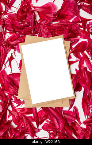 Carta bianca e la busta con il rosso le peonie petali su sfondo grigio Foto Stock