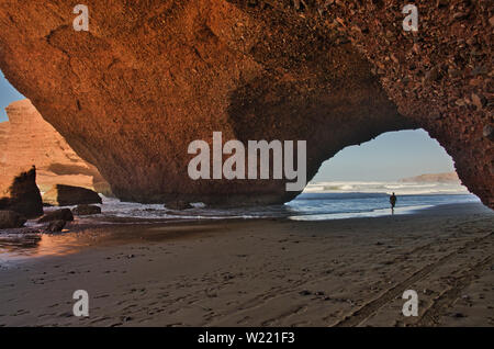 Red Rock con formazione di arco sulla spiaggia, Plage Sidi Ifni, Marocco, Africa Foto Stock