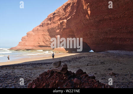 Red Rock con formazione di arco sulla spiaggia, Plage Sidi Ifni, Marocco, Africa Foto Stock