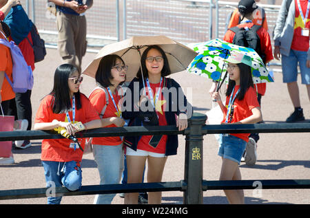 Londra, Inghilterra, Regno Unito. Giapponese studentesse in una calda e soleggiata giornata fuori Buckingham Palace Foto Stock