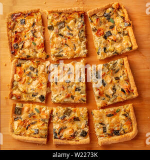 A casa le zucchine e formaggio di capra con torta di salvia, ripresa dall'alto su un tagliere di legno Foto Stock