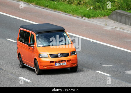 2004 arancione Volkswagen VW Transporter T30 104 TDI; M6, Lancaster, Regno Unito; il traffico veicolare, trasporti, moderno, carrozze salone, nord-limite a 3 lane motorway autostrada. Foto Stock