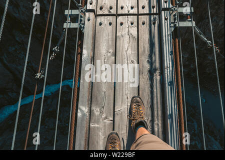 Wanderschuhe von Wanderer auf Triftbrücke über wilder Schlucht in den Schweizer Alpen Foto Stock