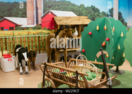 Giocattolo per bambini è farm. Toy ovini, suini, mucca grande su una fattoria Foto Stock