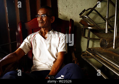 ANTIPOLO City, Filippine - luglio 3, 2019: un maturo uomo filippino si siede su una sedia e pone per la fotocamera. Foto Stock