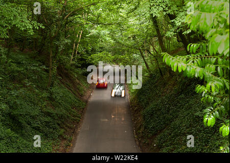 Ripido stretto viottolo di campagna, Vigo Hill, con grandi a strapiombo di alberi decidui con rive scoscese attraverso chalk, cercando in discesa Foto Stock