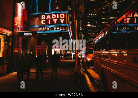 RADIO CITY MUSIC HALL: riprese notturne di passanti e le notti al neon della Radio City Music Hall di New York - Aprile 2019, New York, NY, STATI UNITI D'AMERICA Foto Stock