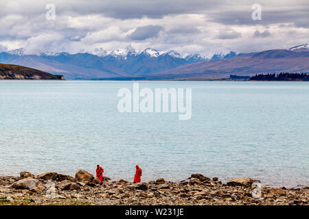 Due monaci buddisti sulla spiaggia al Lago Tekapo, regione di Canterbury, Isola del Sud, Nuova Zelanda Foto Stock