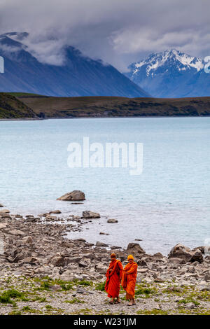 Due monaci buddisti sulla spiaggia al Lago Tekapo, regione di Canterbury, Isola del Sud, Nuova Zelanda Foto Stock