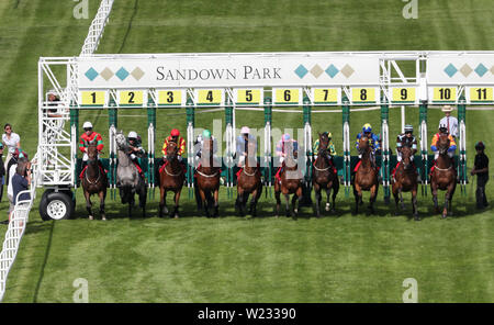 I corridori rompere le bancarelle di partenza nel sequel Handicap durante il Signore giorno del corallo Summer Festival a Sandown Park Racecourse, Esher. Foto Stock